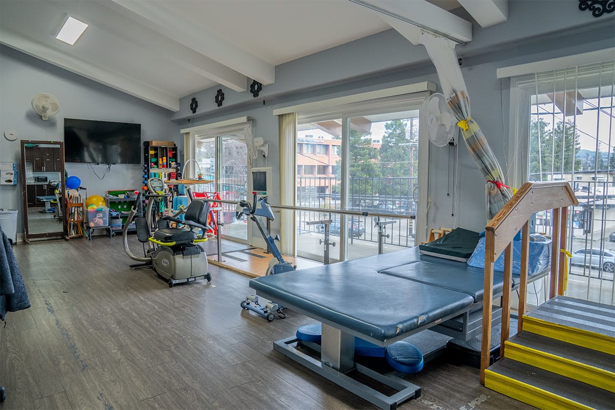 east bay post acute rehabilitation gym with equipment and wood floors with high ceilings
