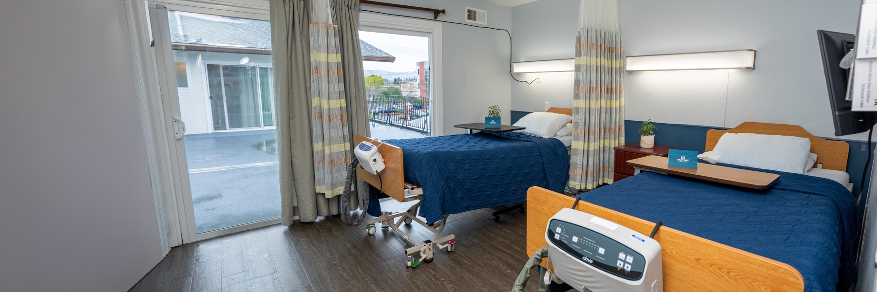 east bay post acute resident room with two large beds and large windows